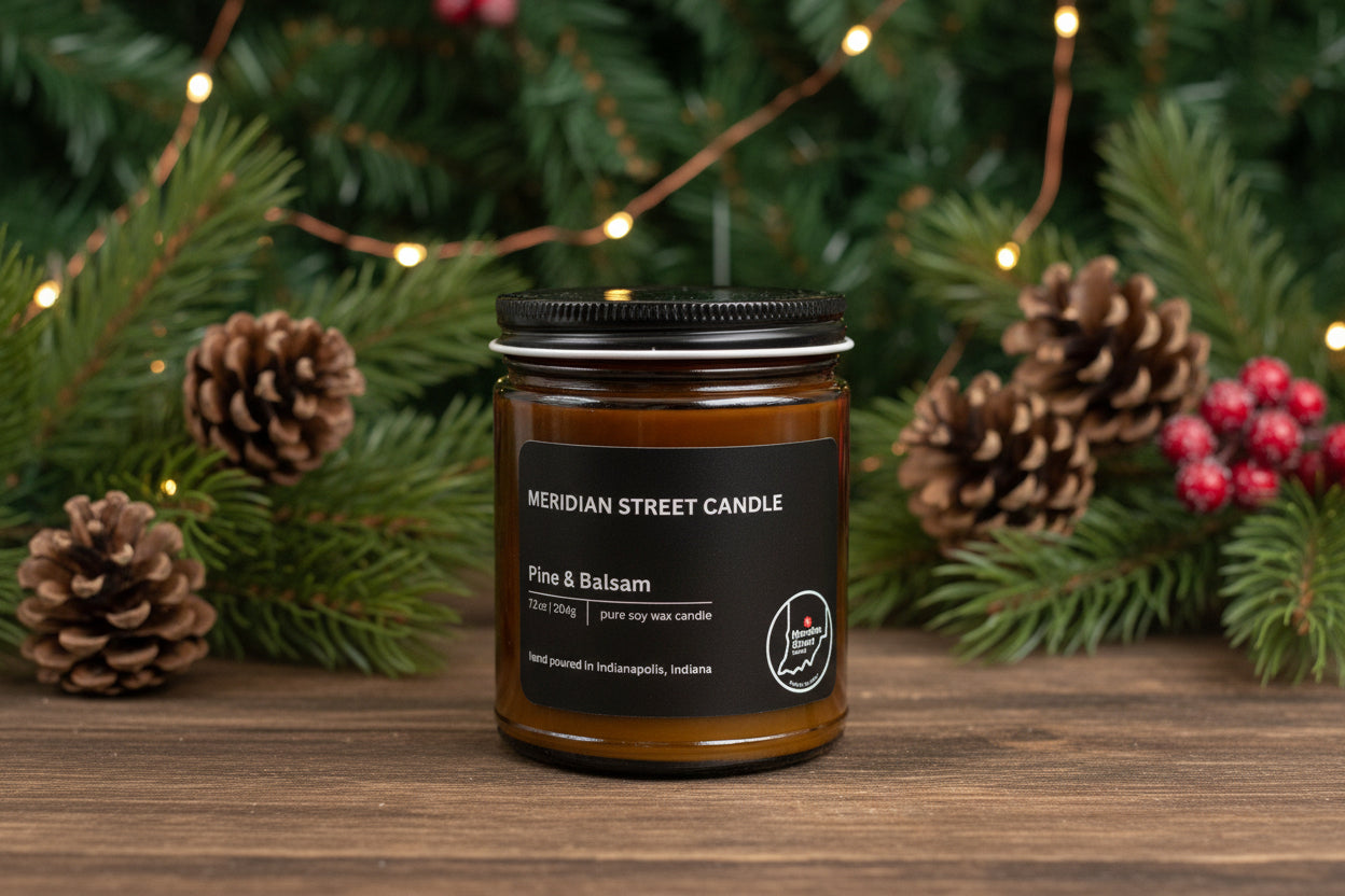 Meridian Street Candle jar with pine cones and Christmas decorations on a wooden surface