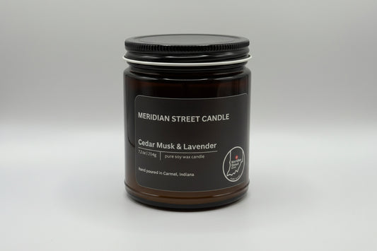 Black candle jar with 'Meridian Street Candle' label on a gray background