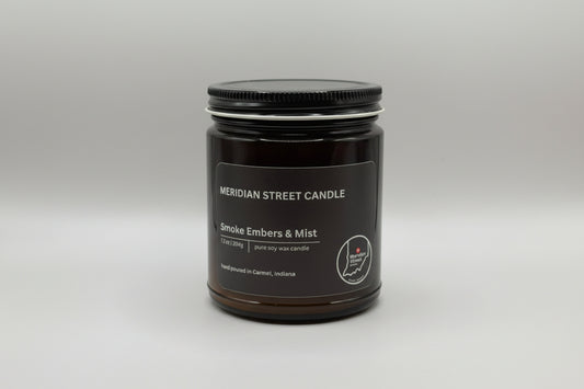 Black candle jar labeled 'Meridian Street Candle' with 'Smoke Embers & Mist' on a gray background