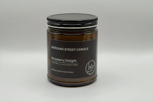 Meridian Street Candle jar labeled 'Strawberry Delight' on a gray background