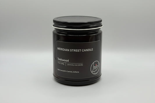 Black candle jar with 'Meridian Street Candle' label on a light gray background